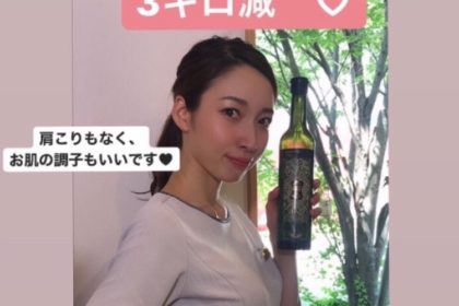 女性がワインのボトルを持っています。