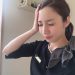 頭にリボンが付いた黒いシャツを着た女性。