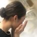 女性が洗面台で顔を洗っています。