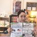 店内でポスターを掲げる女性。