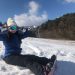 雪の中スノーボードに座る女性。